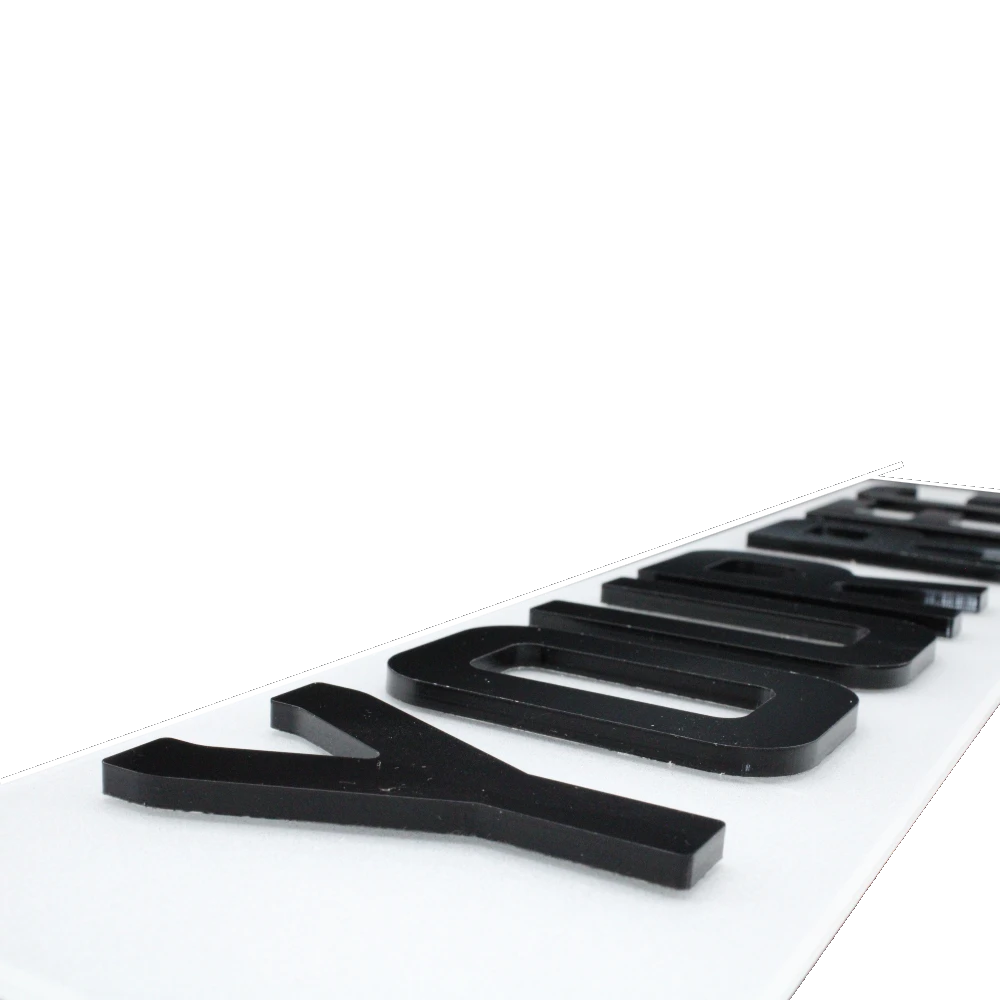 Close-up of raised 5mm black acrylic digits on a white plate.