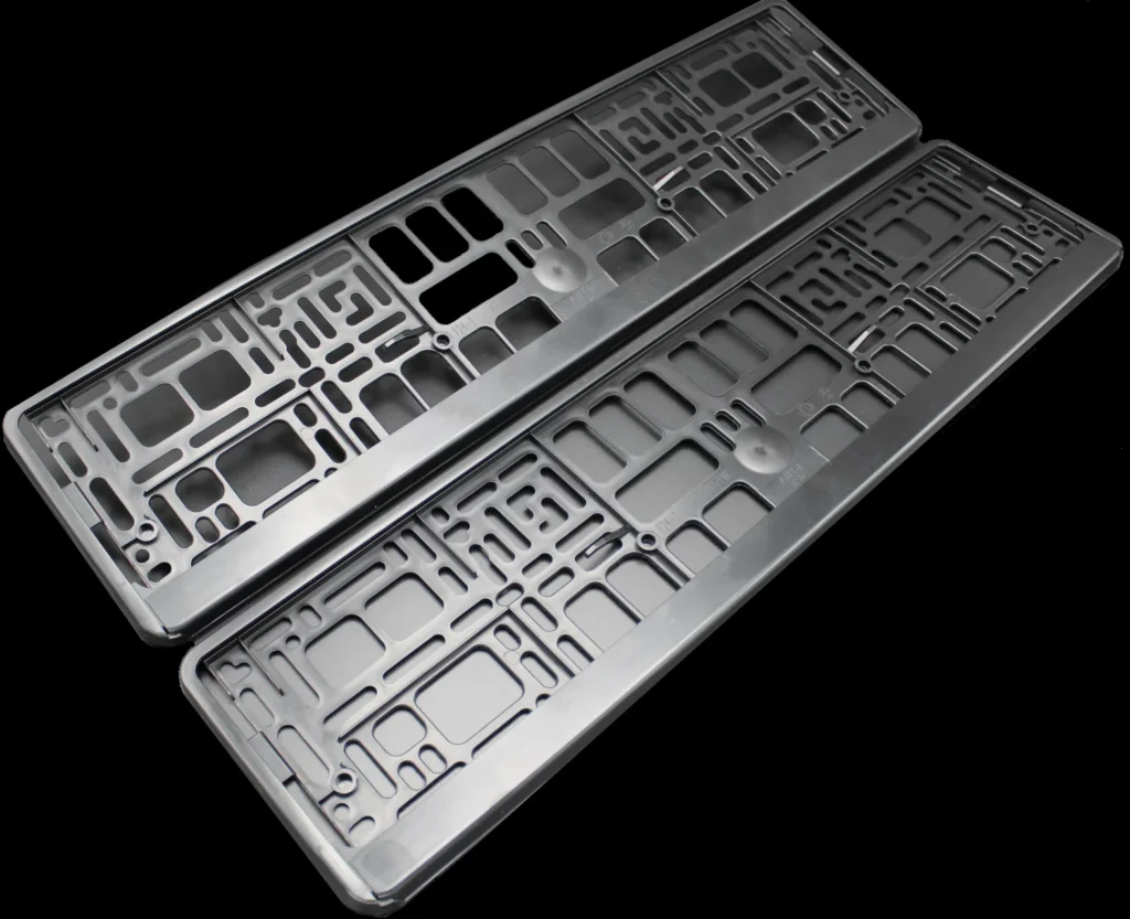 Pair of black plastic number plate holders for cars.